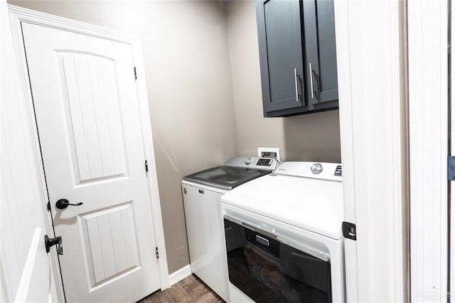 clothes washing area with cabinets, dark parquet flooring, and washer and dryer