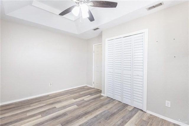 unfurnished bedroom featuring a closet, light hardwood / wood-style floors, and ceiling fan