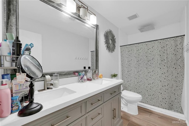1103 Sun Valley St, San Juan, TX 78589 - bathroom with a shower with curtain, wood finished floors, toilet, double vanity, and baseboards
