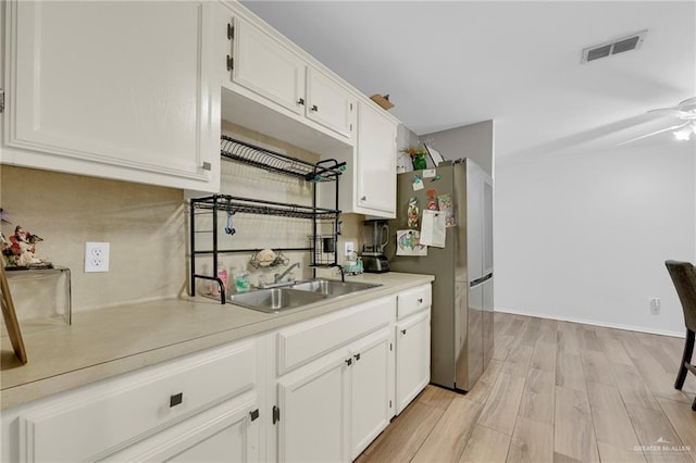 1103 Sun Valley St, San Juan, TX 78589 - kitchen featuring freestanding refrigerator, a sink, white cabinets, light countertops, and light wood-type flooring