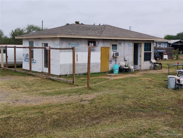 rear view of house with a lawn and cooling unit