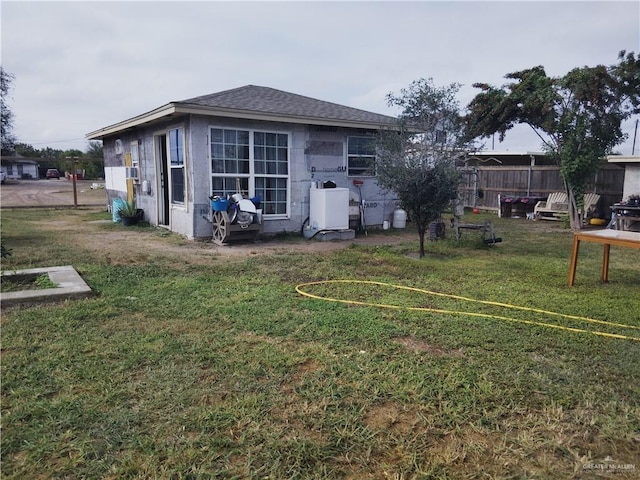 rear view of property featuring a lawn