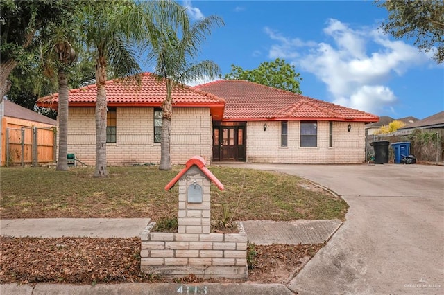 4113 Sonora Ave, Mcallen, TX 78503 - view of front of home with fence, a front yard, brick siding, driveway, and a tile roof