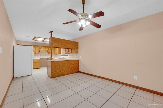 4113 Sonora Ave, Mcallen, TX 78503 - kitchen with freestanding refrigerator, a peninsula, ceiling fan, light countertops, and backsplash