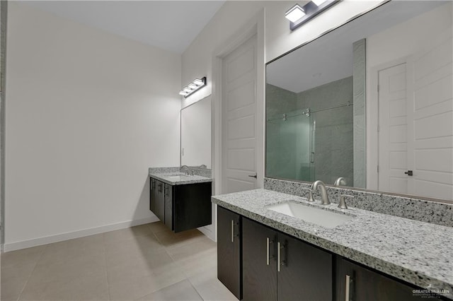 4712 S Waterford Ave, Edinburg, TX 78539 - bathroom with a shower stall, two vanities, tile patterned floors, and baseboards