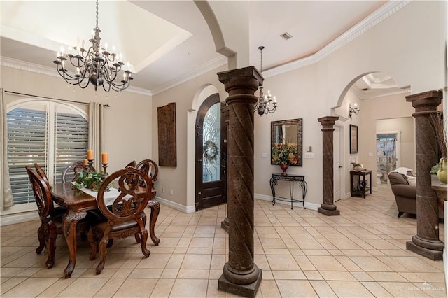 tiled dining space with decorative columns, ornamental molding, a notable chandelier, and a tray ceiling