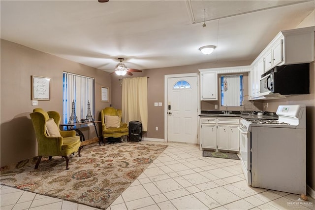 kitchen with white cabinetry, sink, ceiling fan, and white gas range oven