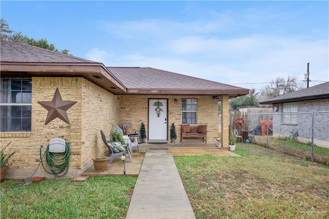 bungalow featuring roof with shingles, fence, and brick siding