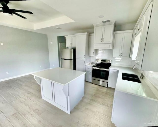 kitchen featuring light countertops, appliances with stainless steel finishes, a center island, and white cabinets