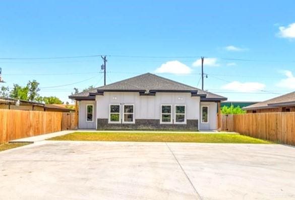 view of front of home featuring a patio area, a fenced backyard, and a front lawn