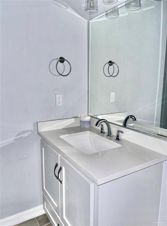 bathroom with tile patterned flooring, baseboards, and vanity