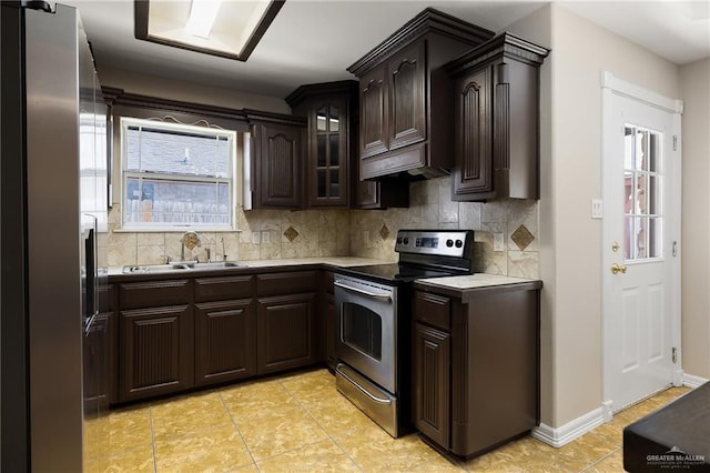 kitchen featuring appliances with stainless steel finishes, a sink, dark brown cabinetry, and decorative backsplash