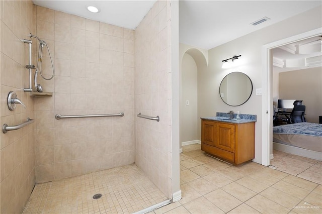 bathroom featuring tile patterned flooring, a tile shower, and visible vents