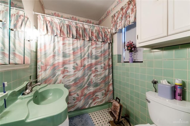 bathroom with shower / bath combo, toilet, and tile walls