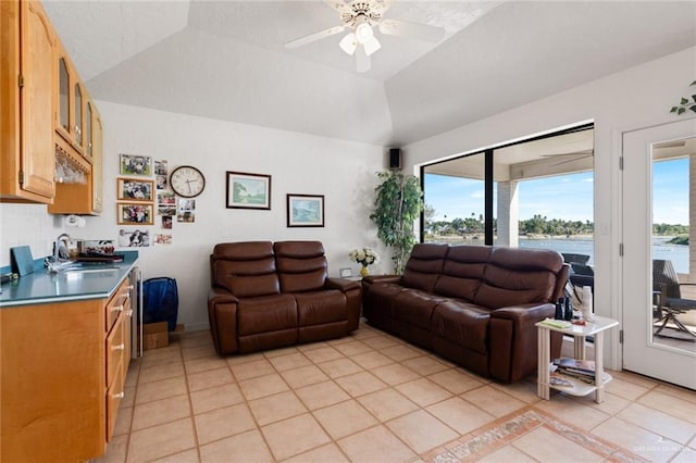 living room with light tile patterned flooring, vaulted ceiling, ceiling fan, and sink