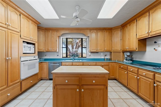 kitchen with a kitchen island, white appliances, sink, and light tile patterned floors