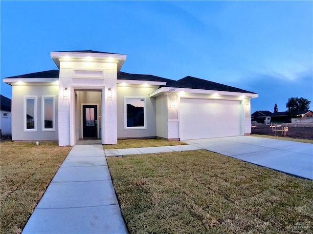 2602 Sunrise Ln, Weslaco, TX 78596 - view of front facade with an attached garage, driveway, a front lawn, and stucco siding