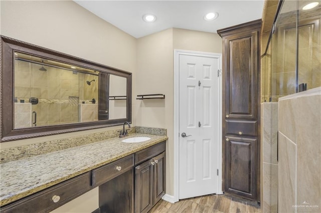 bathroom featuring vanity, wood-type flooring, and walk in shower