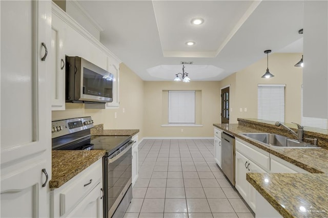 kitchen featuring appliances with stainless steel finishes, sink, pendant lighting, an inviting chandelier, and white cabinets