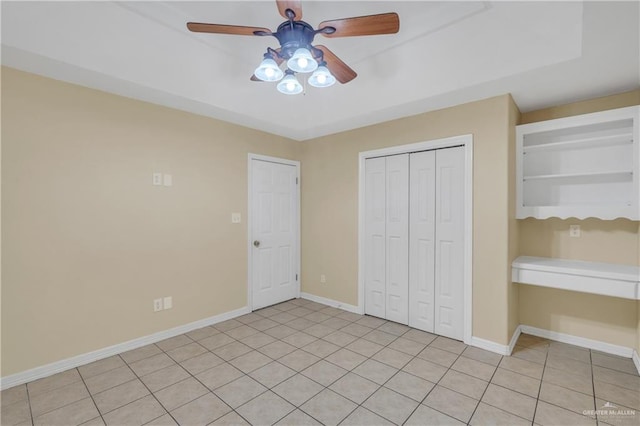 unfurnished bedroom featuring ceiling fan, light tile patterned floors, and a closet