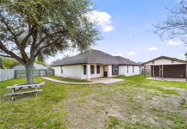 back of house with a sunroom, a patio area, and a lawn