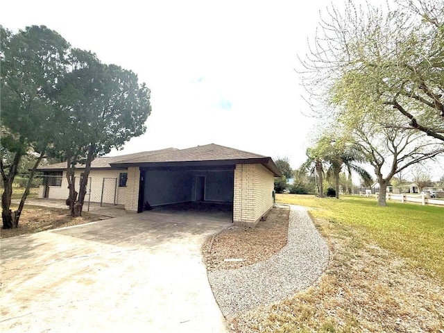 view of side of home with driveway, a yard, and brick siding