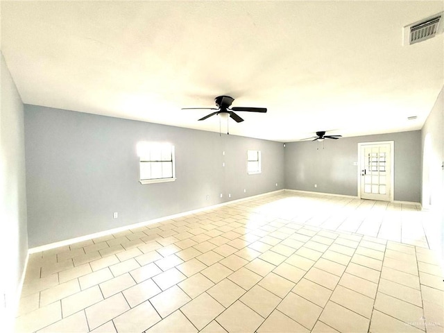 spare room featuring visible vents, ceiling fan, baseboards, and light tile patterned floors