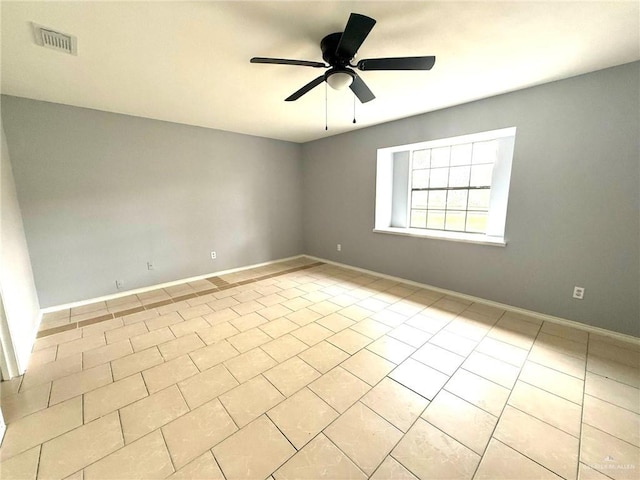 spare room with baseboards, visible vents, a ceiling fan, and light tile patterned flooring