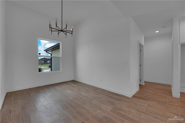 unfurnished dining area with a chandelier and light hardwood / wood-style flooring