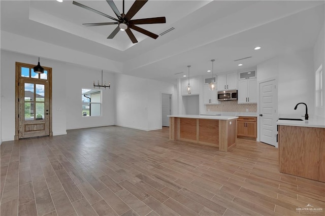 kitchen with white cabinetry, sink, ceiling fan, and light wood-type flooring