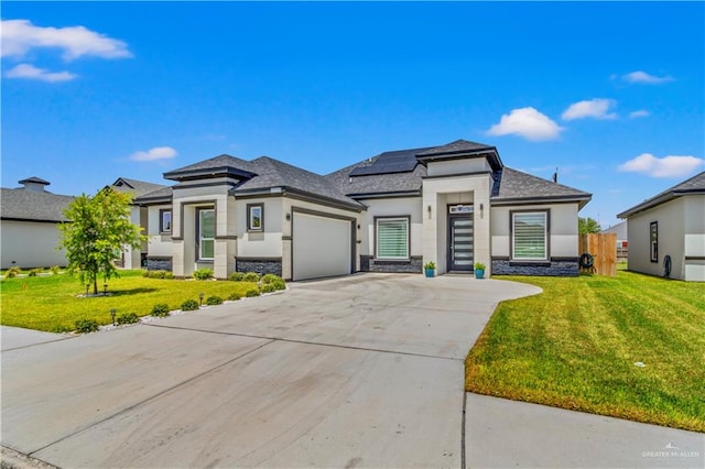 prairie-style house featuring solar panels, a garage, and a front lawn