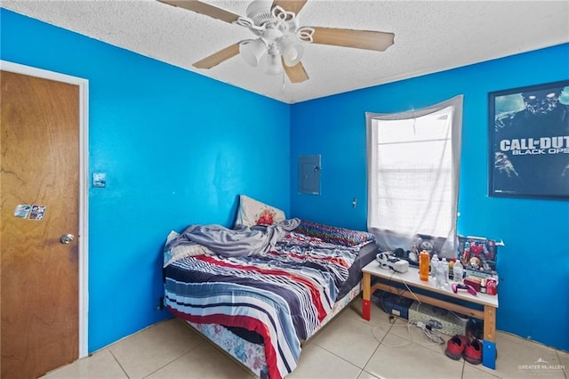 bedroom featuring ceiling fan, electric panel, a textured ceiling, and light tile patterned floors