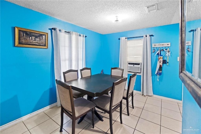 tiled dining area featuring cooling unit and a textured ceiling