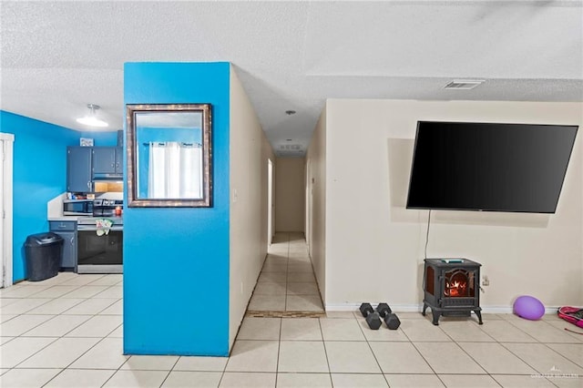 corridor with light tile patterned flooring and a textured ceiling