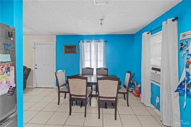 tiled dining area featuring cooling unit and a textured ceiling