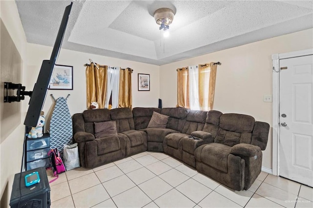 living room featuring light tile patterned flooring, a raised ceiling, and a textured ceiling