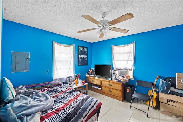 bedroom with light tile patterned flooring, ceiling fan, electric panel, and a textured ceiling