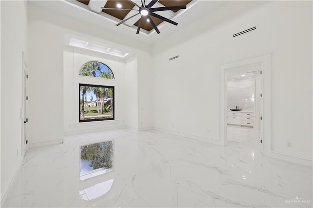 3910 La Hacienda St, Weslaco, TX 78596 - empty room featuring baseboards, marble finish floor, ceiling fan, visible vents, and a towering ceiling