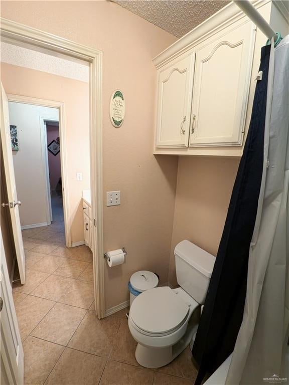 bathroom featuring tile patterned flooring, vanity, a textured ceiling, and toilet