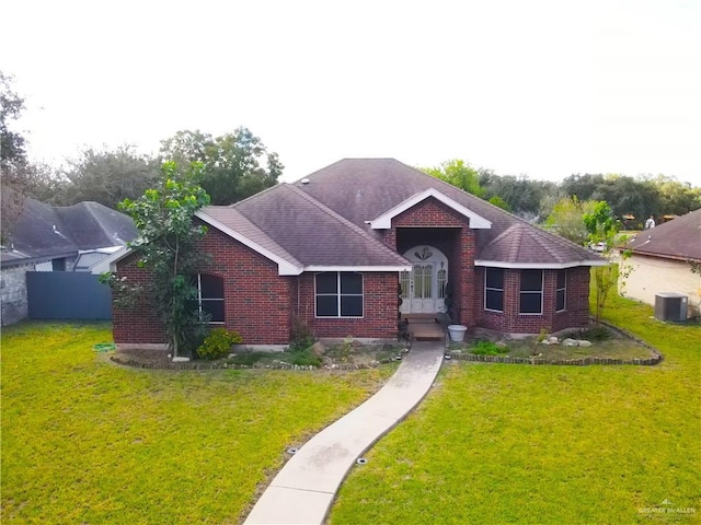 ranch-style home with a front yard and central AC unit