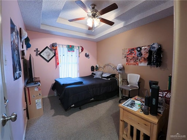 carpeted bedroom featuring ceiling fan and a raised ceiling