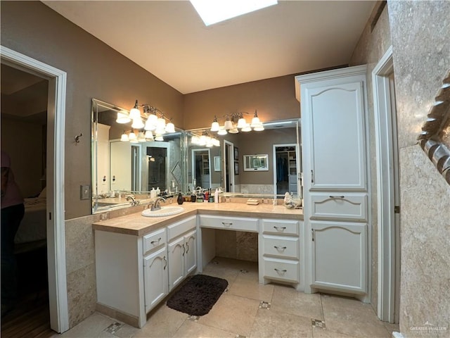 bathroom with tile patterned flooring, vanity, and a chandelier