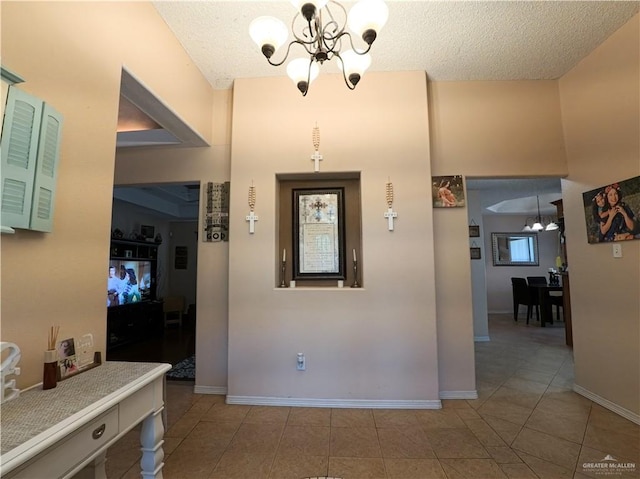 entryway featuring light tile patterned floors, a textured ceiling, and a chandelier