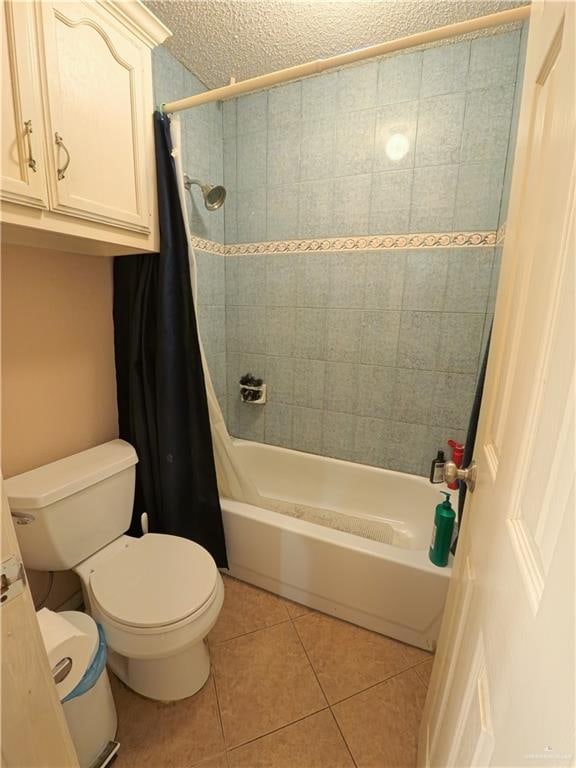 bathroom featuring tile patterned floors, toilet, a textured ceiling, and shower / tub combo