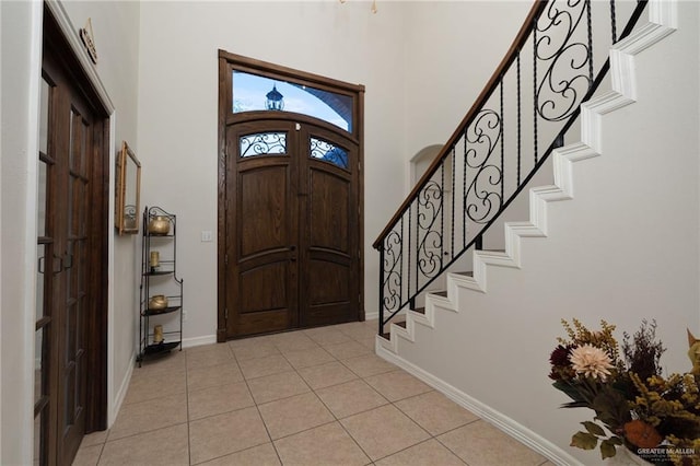 622 Comedy Ln, Edinburg, TX 78542 - foyer with stairway, light tile patterned floors, baseboards, and a towering ceiling