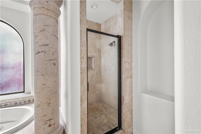 bathroom with a stall shower and a garden tub