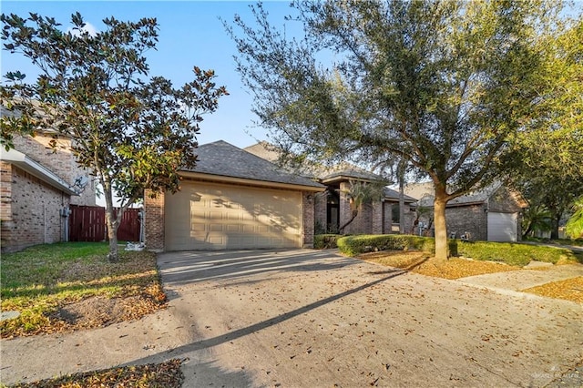 view of front of property featuring brick siding, an attached garage, fence, roof with shingles, and driveway