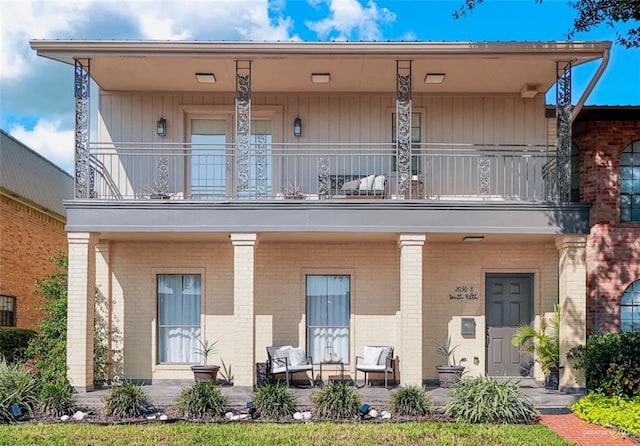 view of front of house with covered porch, a balcony, and a patio