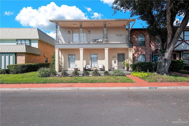 view of front of property featuring covered porch and a balcony