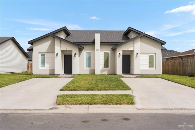 323 Uva Ln, Brownsville, TX 78521 - view of front facade featuring roof with shingles, a front yard, stucco siding, and fence
